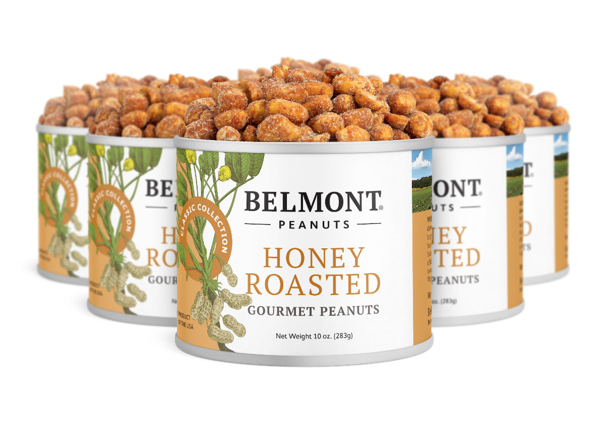 Five cans of Honey Roasted peanuts are arranged together, each with a white label featuring peanut and green leaf designs, and filled with jumbo peanuts coated in sweet golden honey.