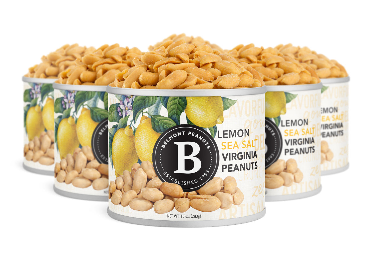Four cans of Lemon Sea Salt are packed with flavorful Virginia peanuts. Each can features bright illustrations of lemons and peanuts, plus the signature Belmont Peanuts logo.
