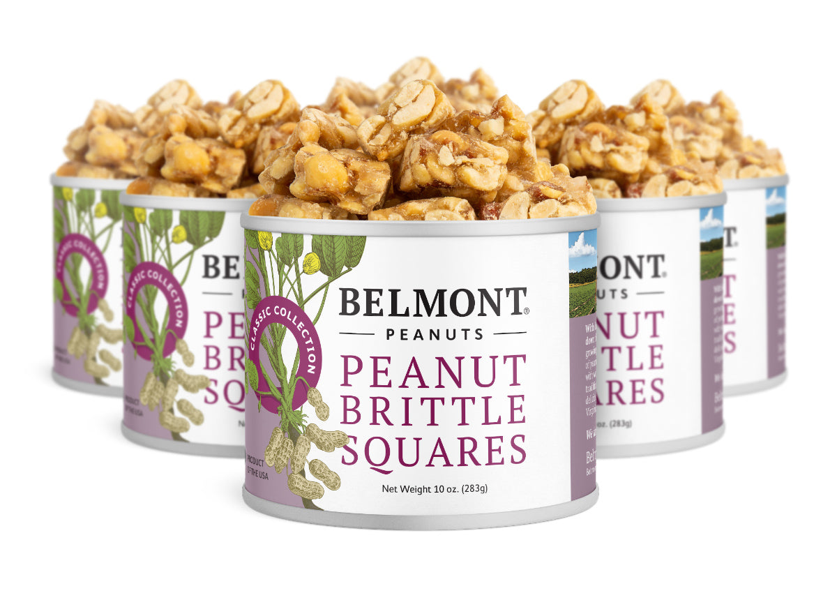 Five cans of Peanut Brittle Squares are filled with chunky, bite-size pieces. Each can has a purple and white label with peanut illustrations, making this sweet snack perfect for any occasion.