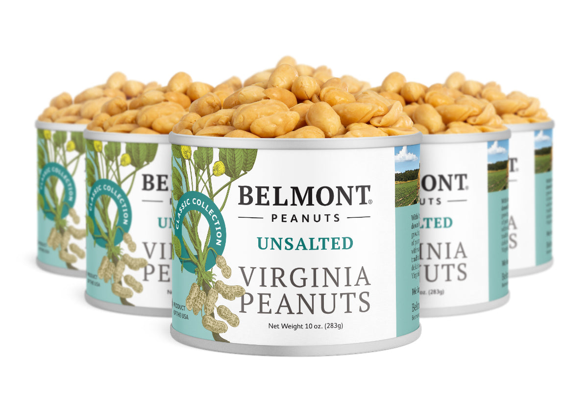 Several cans of Unsalted peanuts are arranged together, open and filled to the top. The white and green labels feature images of peanuts and leaves, highlighting these no salt added snacks.