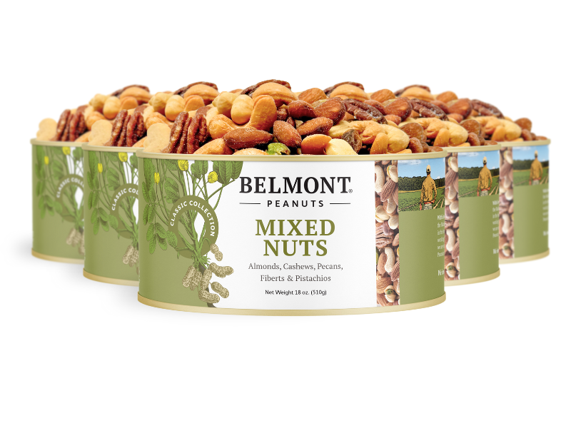 Four cans of Mixed Nuts, featuring almonds, cashews, pecans, filberts, and pistachios, are arranged in a staggered row. The green and cream label displays an image of assorted nuts and a farm scene.