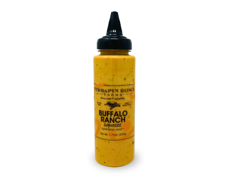 A bottle of Buffalo Ranch Garnishing Sauce with a black cap and yellow-orange label stands upright against a white background—ideal as a garnishing or dipping sauce for your favorite dishes.