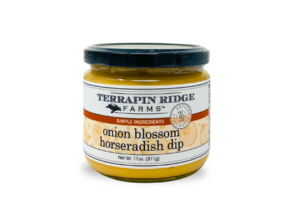 A jar of Onion Blossom Horseradish Dip with a black lid and white label featuring orange and black text, weighing 11 oz (311g). The label highlights "simple ingredients.