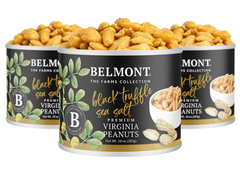 Three cans of Black Truffle Sea Salt Virginia Peanuts are displayed, one open to reveal the seasoned peanuts inside. The label shows images of peanuts, black truffle, and decorative leaves.