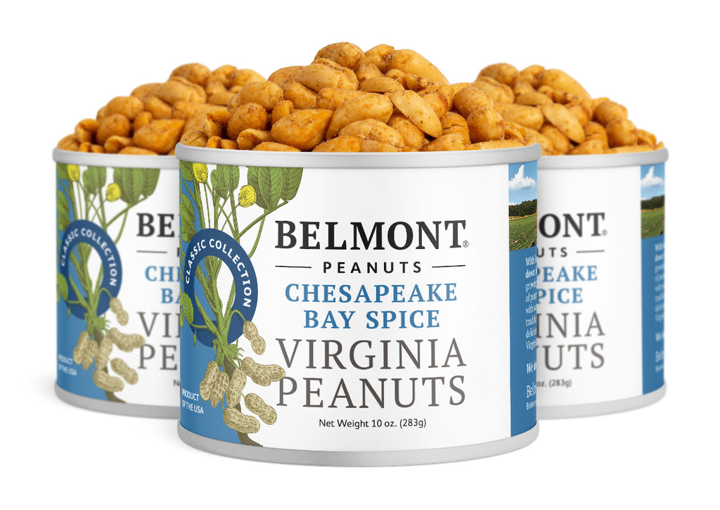 Three cans of Chesapeake Bay Spice peanuts are arranged together, each with a white and blue label featuring illustrations of peanut plants and the product name displayed.