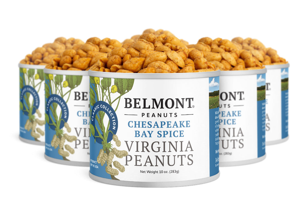 Four cans of Chesapeake Bay Spice Virginia Peanuts, each 10 ounces, are grouped together. The blue and white labels feature coastal scenery, emphasizing the flavorful crab spice seasoning inside.