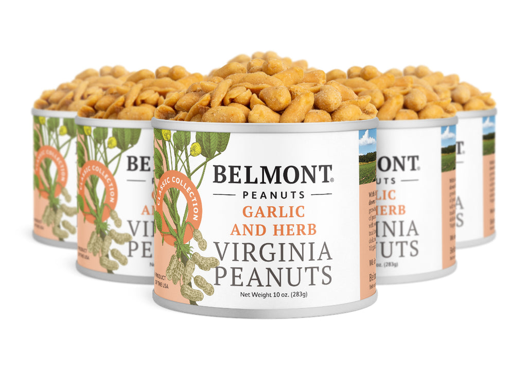 Five cans of Garlic & Herb gourmet Virginia peanuts are arranged together, the front can in focus. Each label displays peanuts and herbs, highlighting a tasty, protein-rich snack packed with flavorful garlic peanuts.