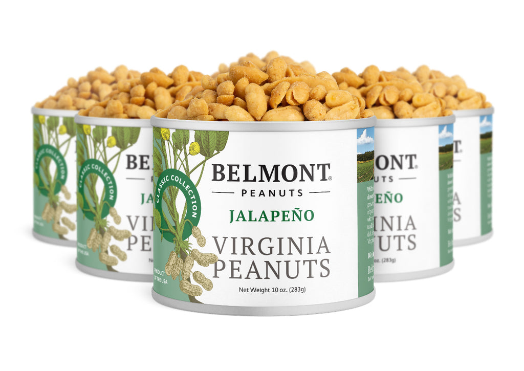 Five cans of Jalapeno are arranged in a staggered row, overflowing with spicy peanuts. The cans feature green and white labels decorated with peanut and leaf illustrations.
