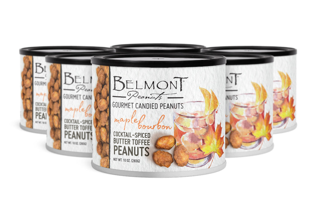Five cans of Belmont Gourmet Butter Toffee Maple Bourbon Peanuts are arranged in rows. The cans show peanuts, a glass of bourbon with ice, and autumn leaves, emphasizing their sweet, buttery maple bourbon flavor.