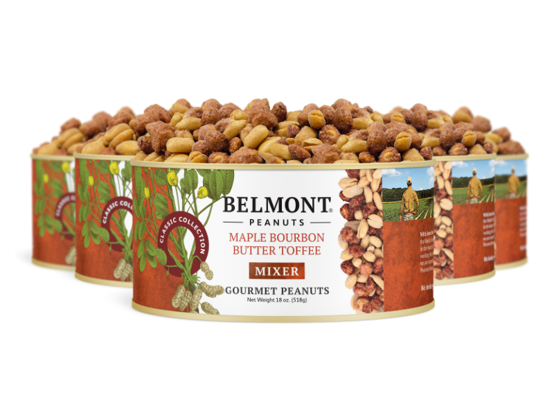 Four cans of Maple Bourbon Butter Toffee Mixer are arranged in a semi-circle, opened to display a pile of assorted butter toffee peanuts. The label features images of peanuts and greenery.