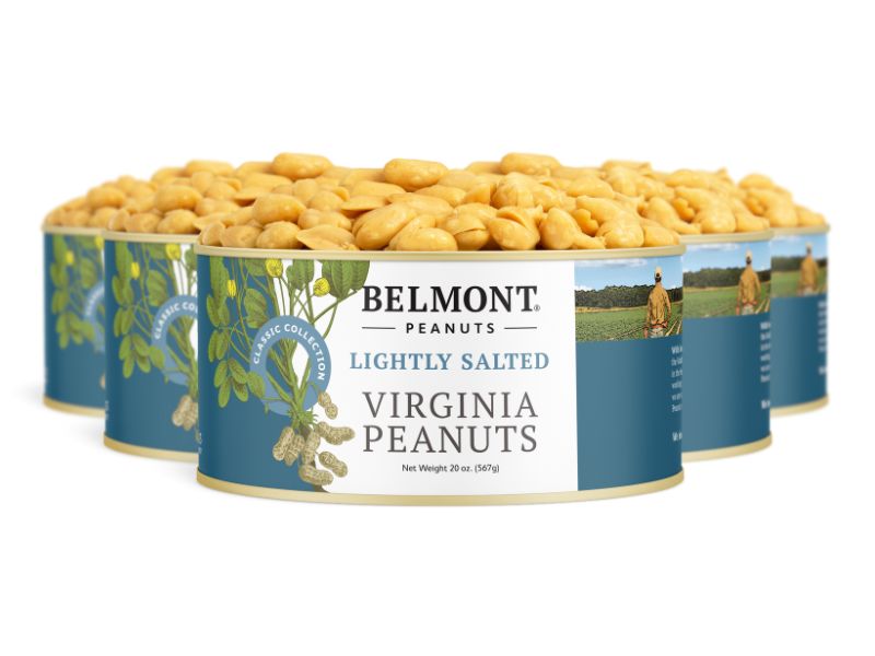 Four cans of Lightly Salted peanuts with a blue label featuring a farm scene and peanut plant illustrations are grouped together. Each can displays shelled peanuts.