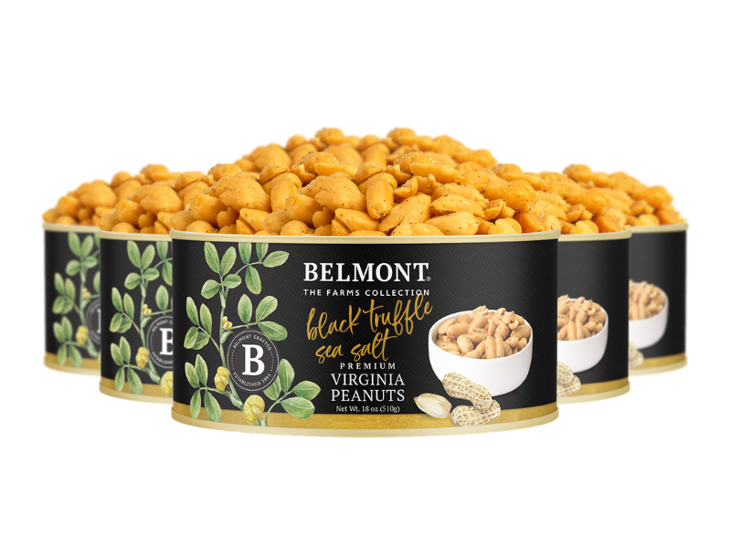 Four cans of Black Truffle Sea Salt peanuts are lined up, each in a black and gold label featuring peanuts and green leaves—a gourmet treat for sea salt peanut lovers.