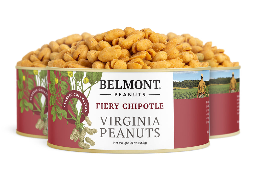 Three cans of Fiery Chipotle Virginia Peanuts are stacked, each with red labels showing peanuts and a farmer in a field. The cans are filled to the top with these protein-packed gourmet snacks.