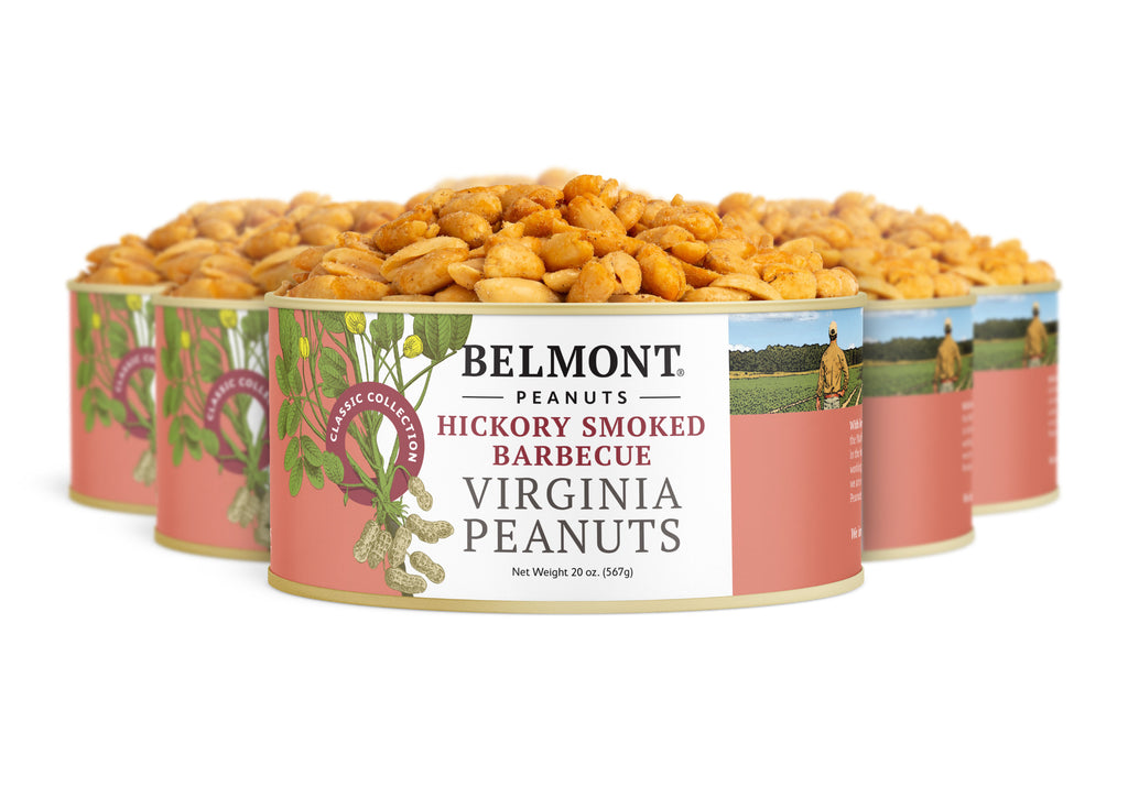 Four cans of Hickory Smoked BBQ Virginia Peanuts are arranged in a semi-circle, displaying the front label featuring images of hickory smoked peanuts, a scenic farm, and prominent red and white branding.