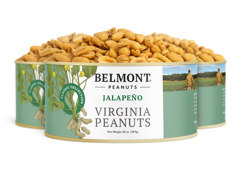 Three cans of Jalapeno peanuts are stacked, showing golden roasted, jalapeno-seasoned nuts inside. The green labels feature illustrations of peanut plants and a farmer in a field.