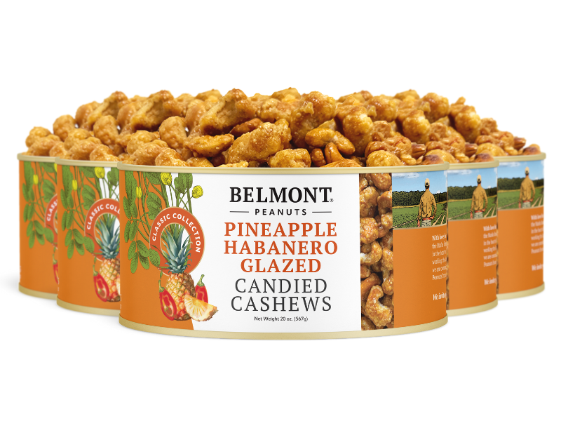 Several cans of Pineapple Habanero Glazed Candied Cashews are stacked in a semicircle, with labels featuring cashews, pineapple, and habanero peppers to highlight this unique spicy snack.