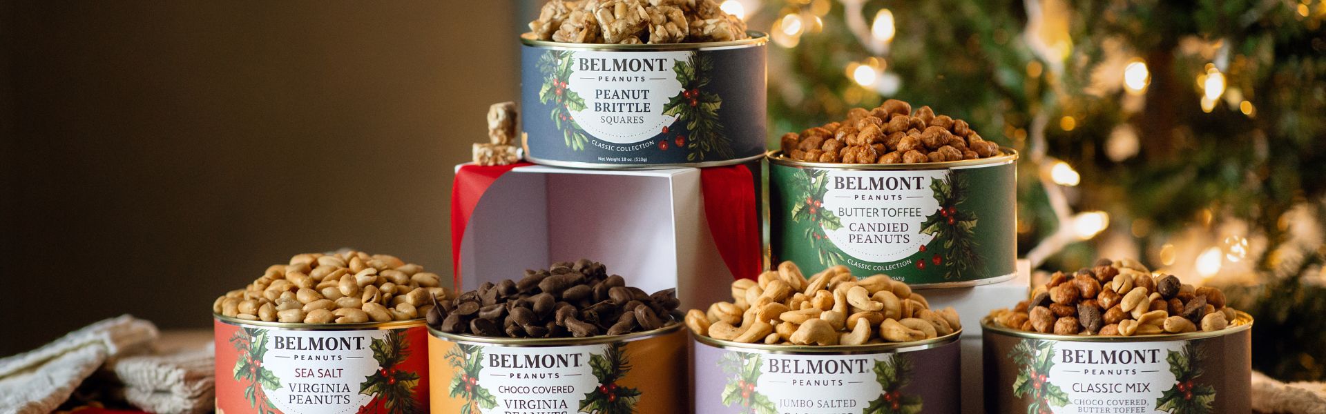 Belmont peanuts containers on a tiered display with Christmas lights in the background